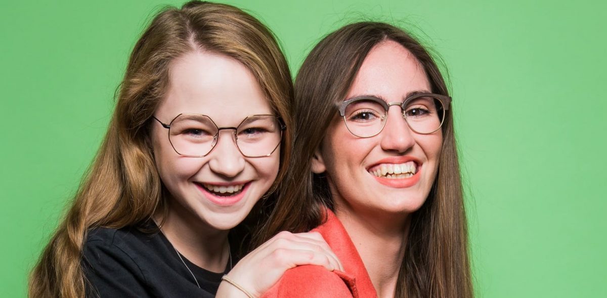 Zwei junge auszubildende Frauen der Augenoptik lächeln