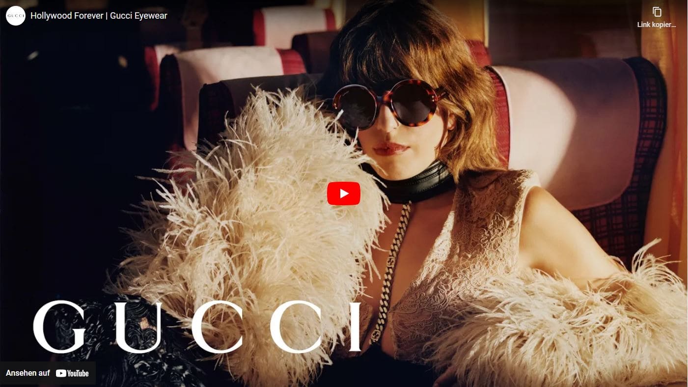 Junge Frau mit Gucci-Sonnenbrille und Federboa im Bus. Gucci Video bei Optiker Gronde